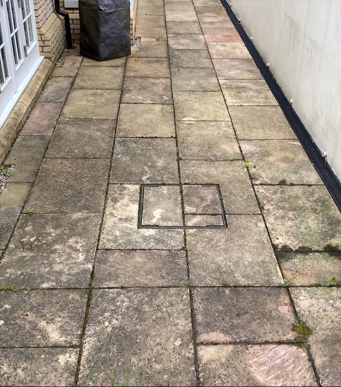 Dirty, stained driveway and home exterior before Apex Power Wash cleaning